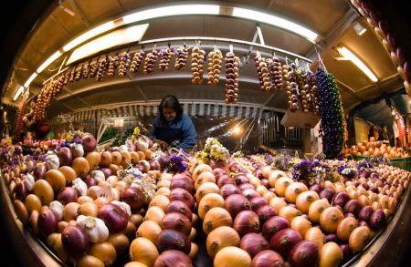 A vendor sells strings of onions at her stall at the annual "Zibelemaerit" onion market in Bern November 23, 2009. Farmers sell more than 50 tonnes (50,000 kg) of onions and garlic during the traditional one-day autumn market in Bern's city centre on the fourth Monday of November. Picture taken with a fish-eye lens. REUTERS/Michael Buholzer (SWITZERLAND SOCIETY BUSINESS IMAGES OF THE DAY)